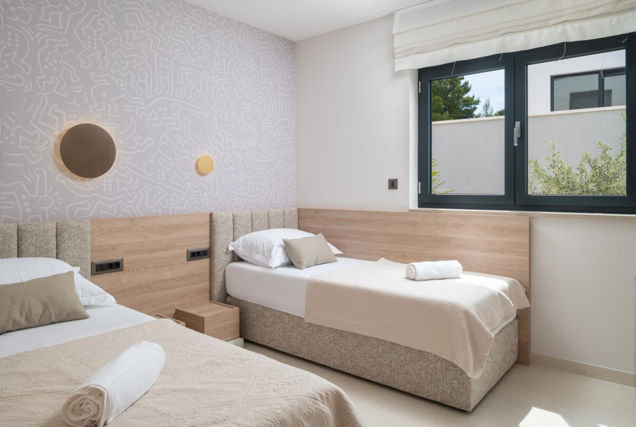Bedroom 2 (13 sqm) with two single beds and en-suite facilities.