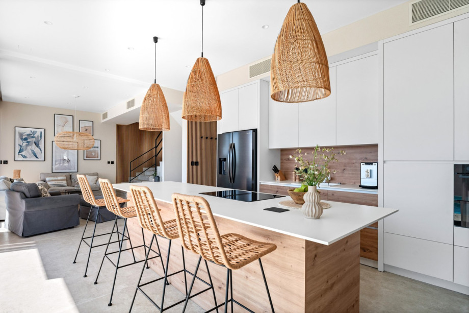 And a fully equipped kitchen with a spacious kitchen island and four stools.