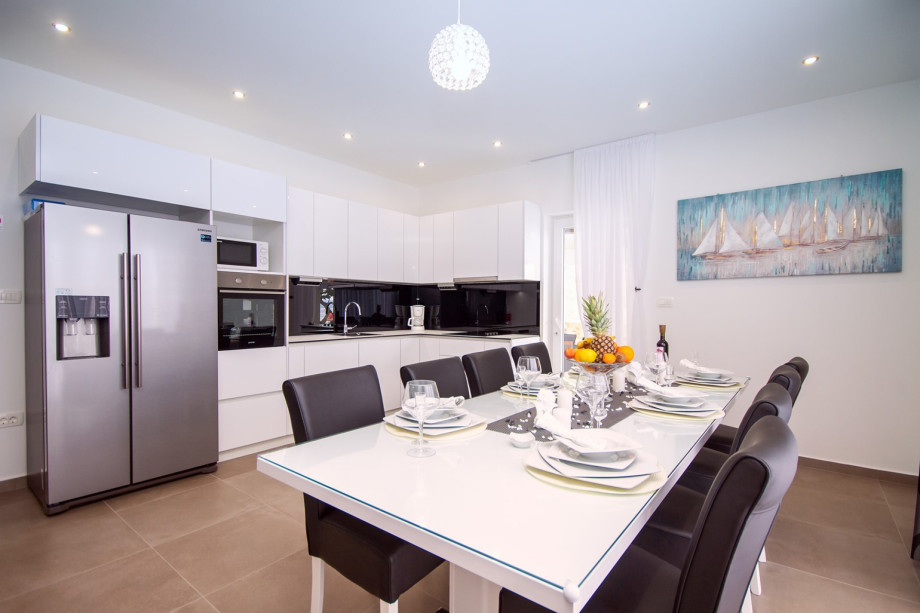 Living and dining area with a table for 12 persons, fully equipped kitchen