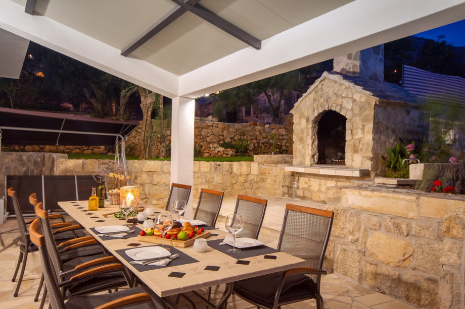 Outdoor dining area and grill in the evening