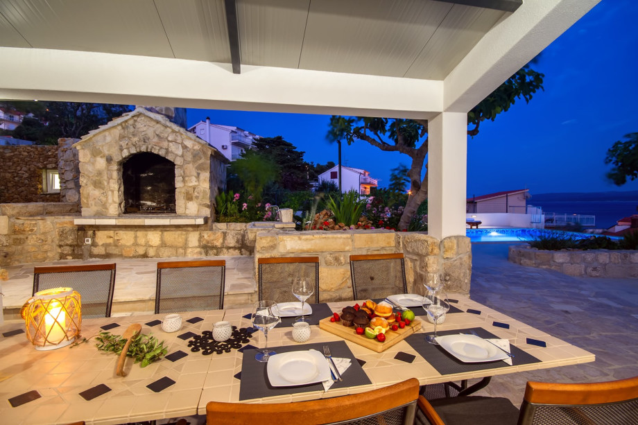 Outdoor dining area and grill in the evening