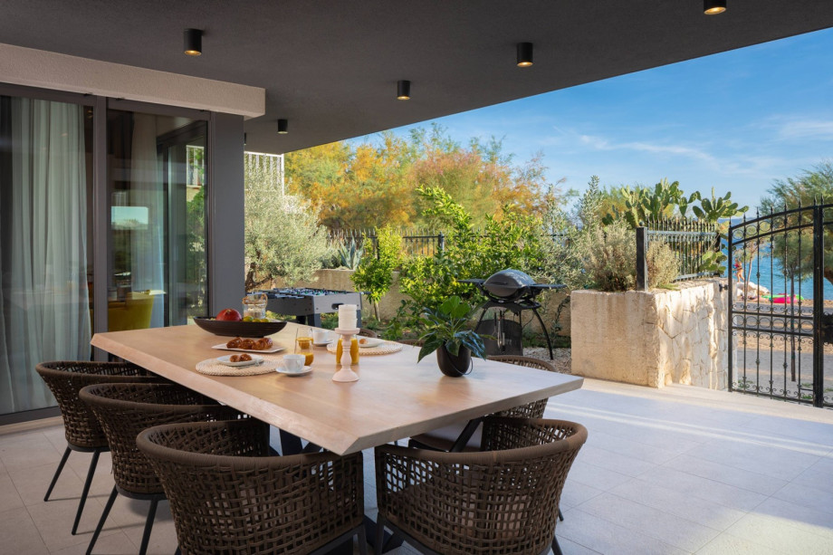 Covered outdoor dining area at ground floor next to the indoor pool area