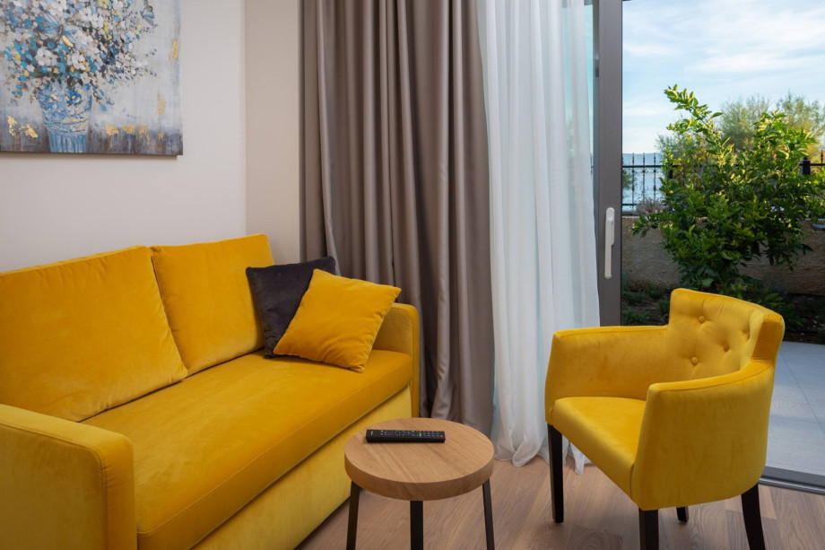 Sofa- und Loungebereich im Schlafzimmer Nr. 4 mit Blick auf den Strand und das Essen im Freien, Erdgeschoss