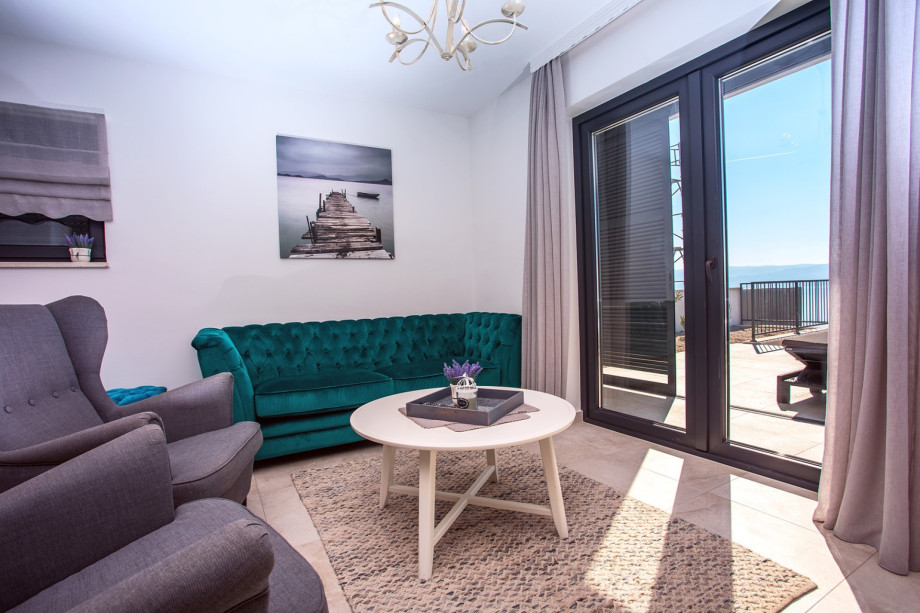 Living area with glass walls toward pool area and amazing sea views