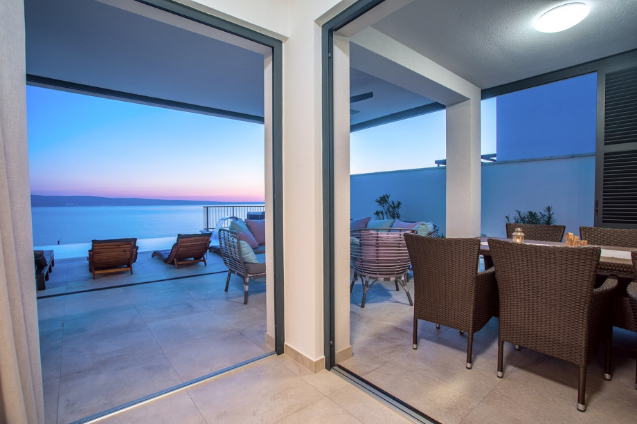 Covered outdoor dining table and lounge corner next to it