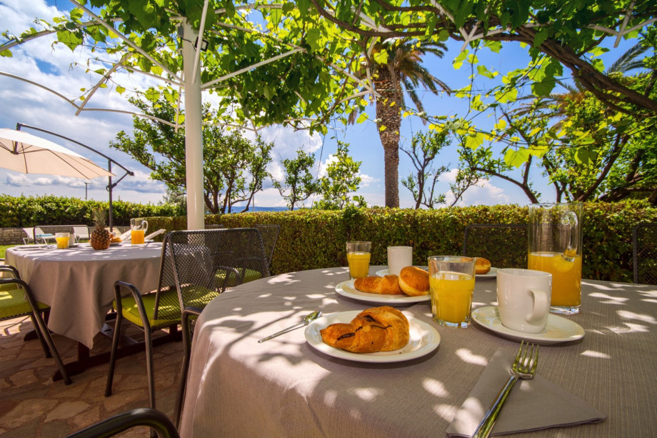 Outdoor dining area with a barbeque in front of the living room and kitchen