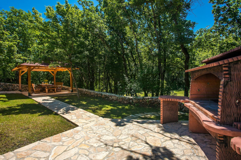 Outdoor dining area for 12 people in a shadow with traditional BBQ