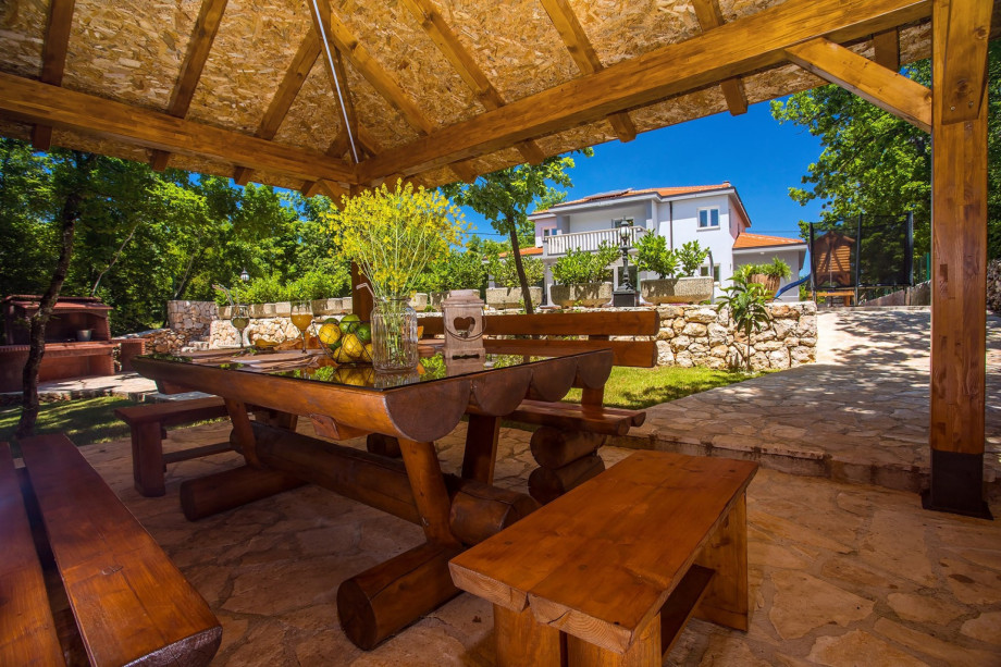 Outdoor dining area for 12 people in a shadow with traditional BBQ