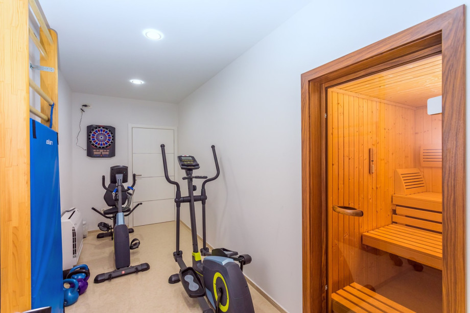 Air-conditioned gym with an exercise bike, Orbitrack, weights, and sauna