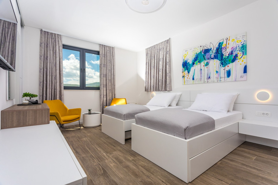 Bedroom No2 with 2 single beds 100cm x 210cm with ability to merge into king size bed,  an en-suite bathroom with shower, a TV, A/C  and a terrace