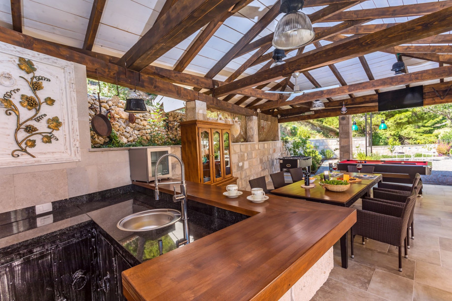 Behind the house is a fully equipped summer kitchen with a covered dining area