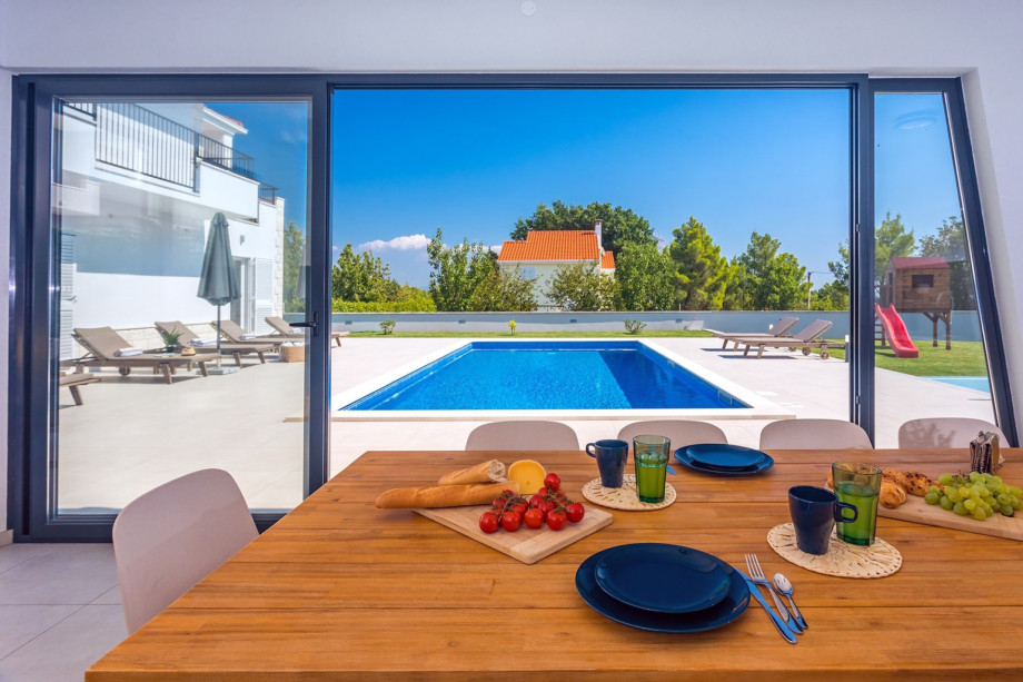 A fully equipped summer kitchen with TV, fridge, barbecue and dining area for 10 pax