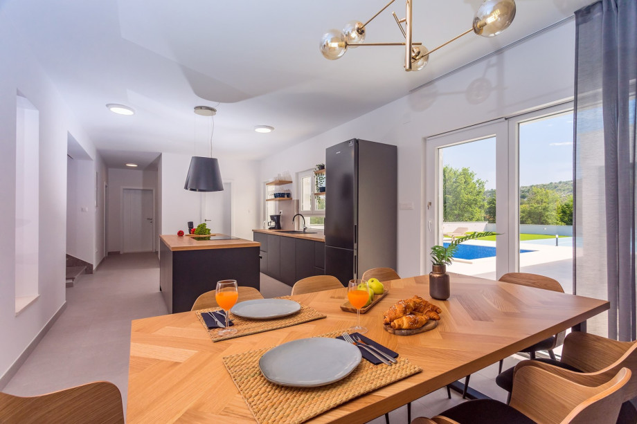 Living area has French doors opening to the pool area with an outdoor kitchen on the side