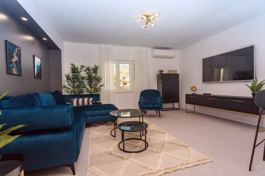 The living room is filled with sofas, and has big screen TV