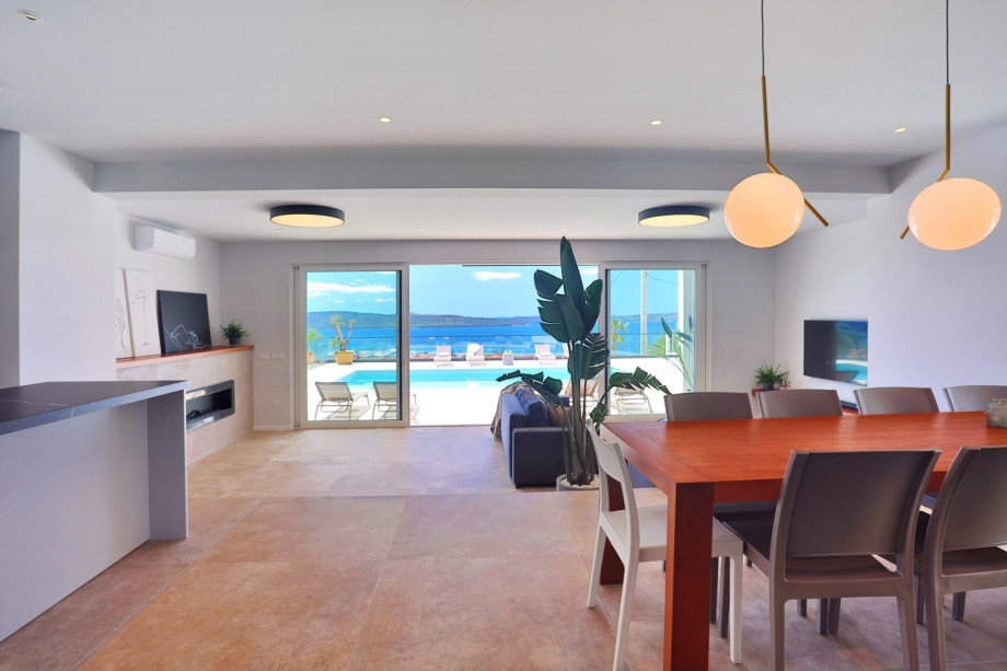 The living area has glass walls toward the pool and outdoor area.