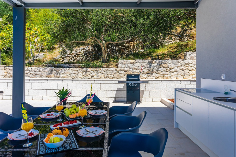 Barbecue is next to the summer kitchen