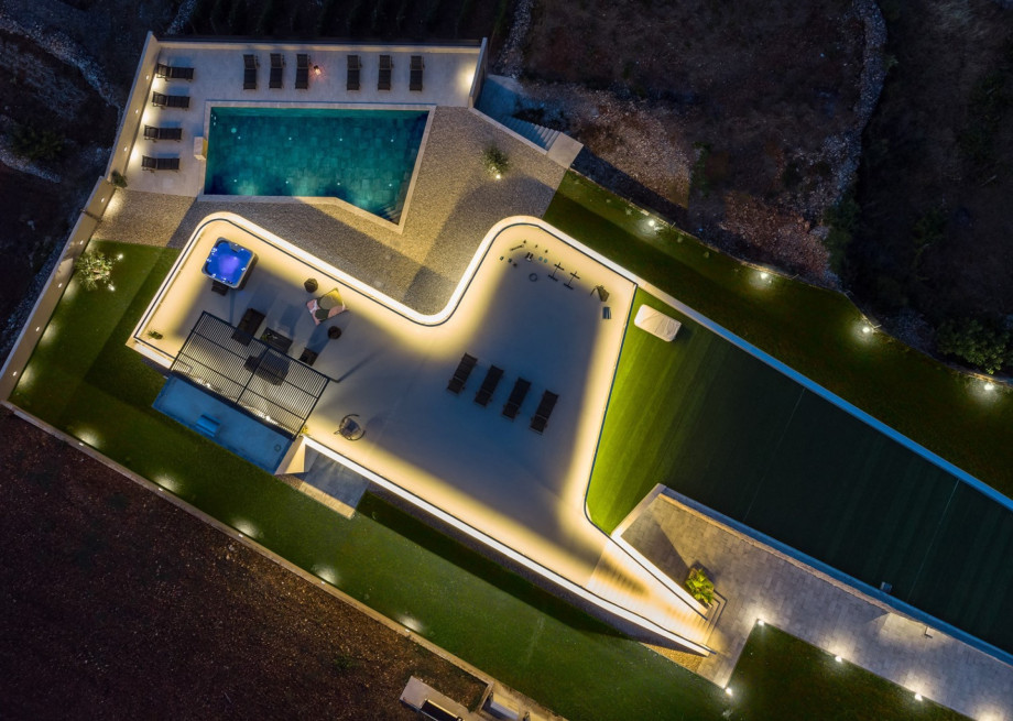 High protective fence brightly illuminated with spotlight lamps at night is a perfect spot for enjoying the evenings