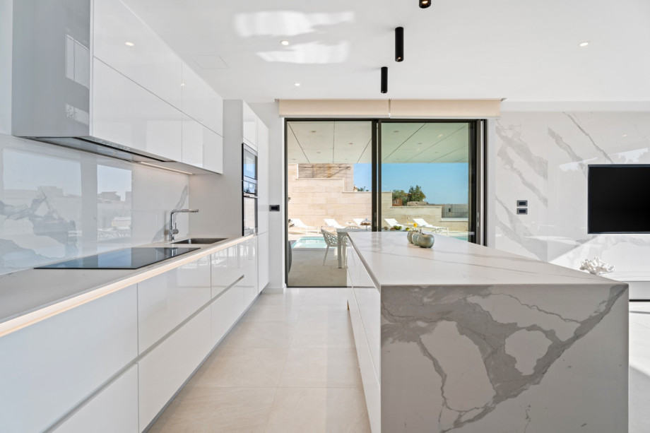 A lounge corner and an outdoor dining area are approachable directly from the kitchen and from the living area.