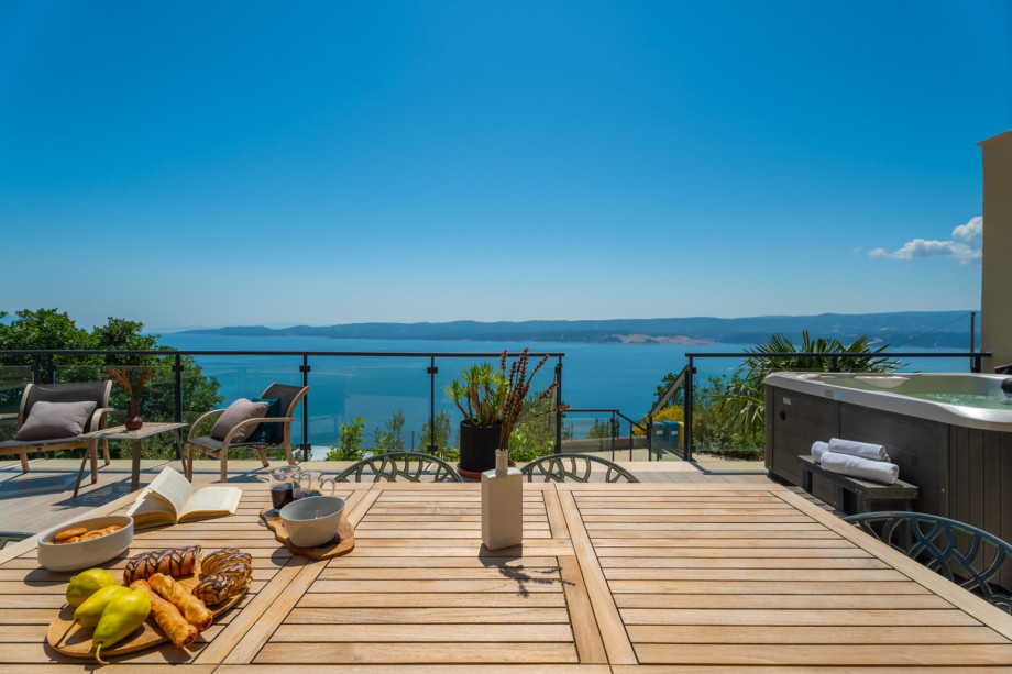 A tropical paradise with a pool, and outdoor furniture.