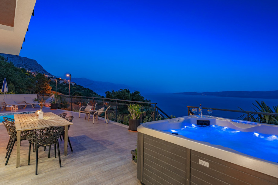 A poolside oasis with azure water, comfortable furniture, and a beautiful view.