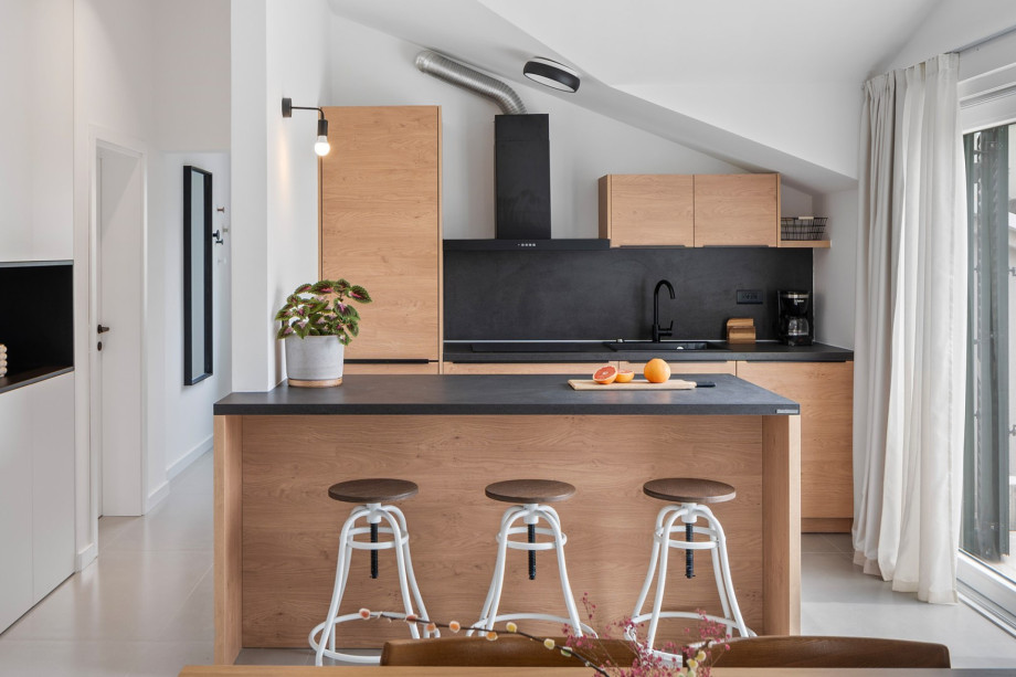 A fully equipped kitchen with a kitchen island and balcony on the second floor