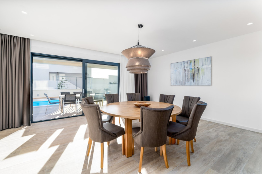 Dining area with a table and direct approach to the pool area and outdoor dining area.