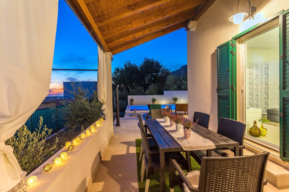 Outdoor dining area next to the pool and kitchen