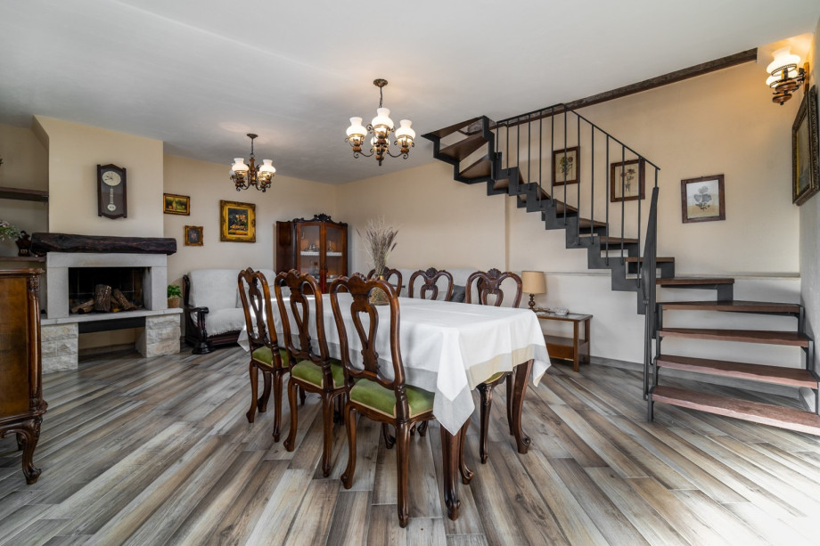 A living area with a dining table, a flat-screen TV, and a fireplace