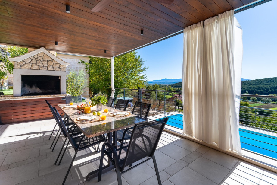 The outdoors offers a covered dining area  and a traditional barbecue