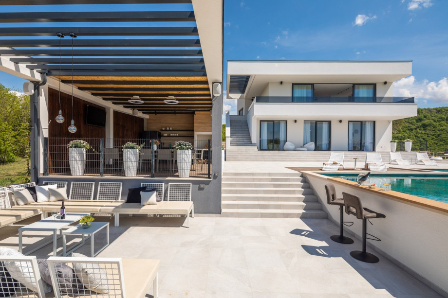 A fully equipped summer kitchen with barbecue and with TV, a covered dining area, a separate toilet