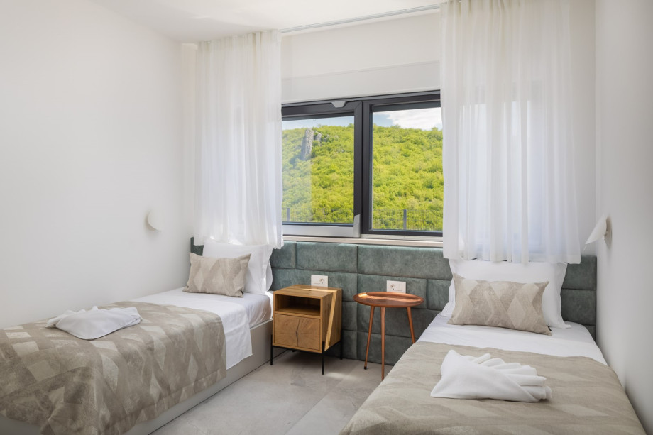 Bedroom No5 (13sqm) with two single beds 90cm x 200cm, A/C, and a family bathroom (3,2sqm) with shower next door