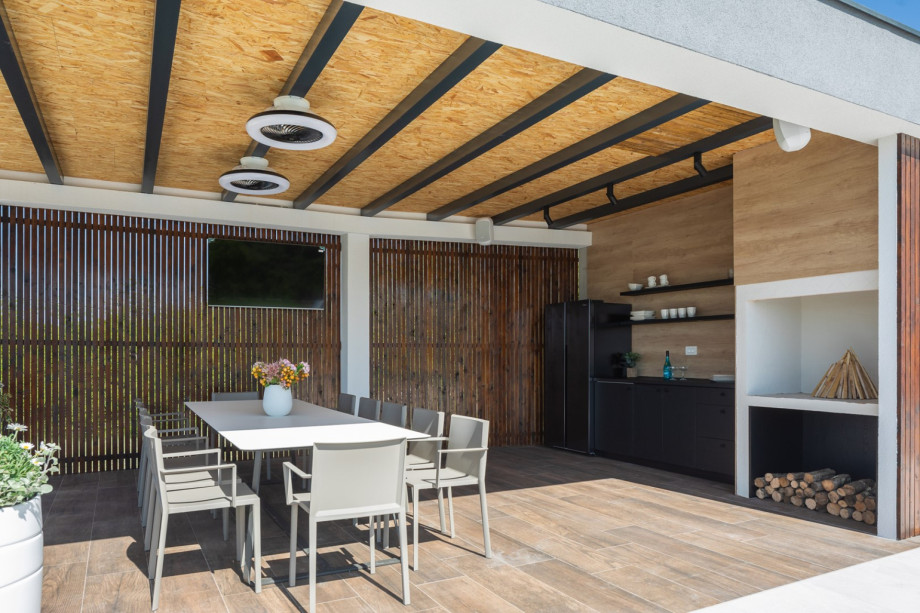 The outdoors offers a covered dining area  and a traditional barbecue