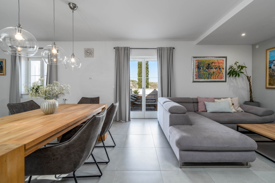 A stylish open plan kitchen and living area with glass doors toward pool area.