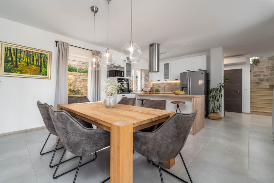 The ground floor offers a fully equipped kitchen with a dining table for 8 people