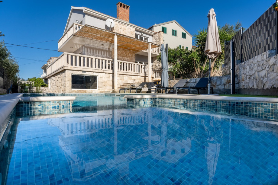 Sun deck area with 8 deck chairs on two levels and there is an outdoor shower.