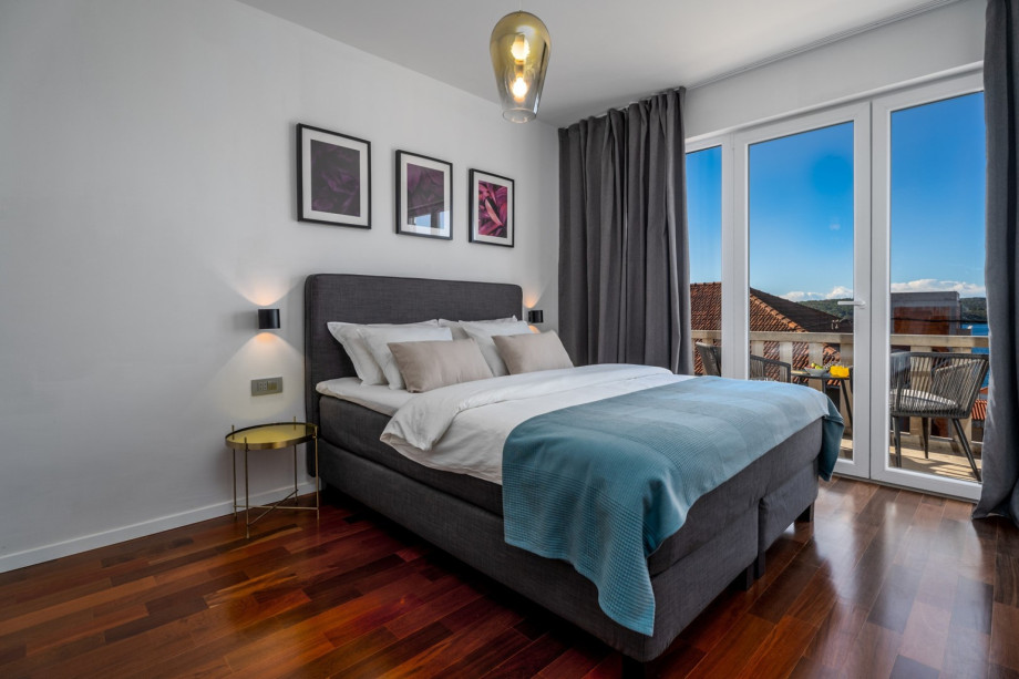Bedroom No2 with a balcony with two chairs, sea views.