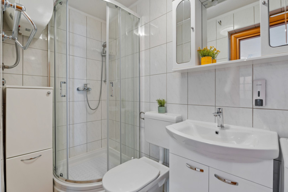 A family bathroom with a shower and a washing machine