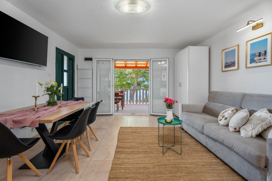 A dining table for 6 people, a TV, an Air-condition, a sofa that can open into a sofa bed