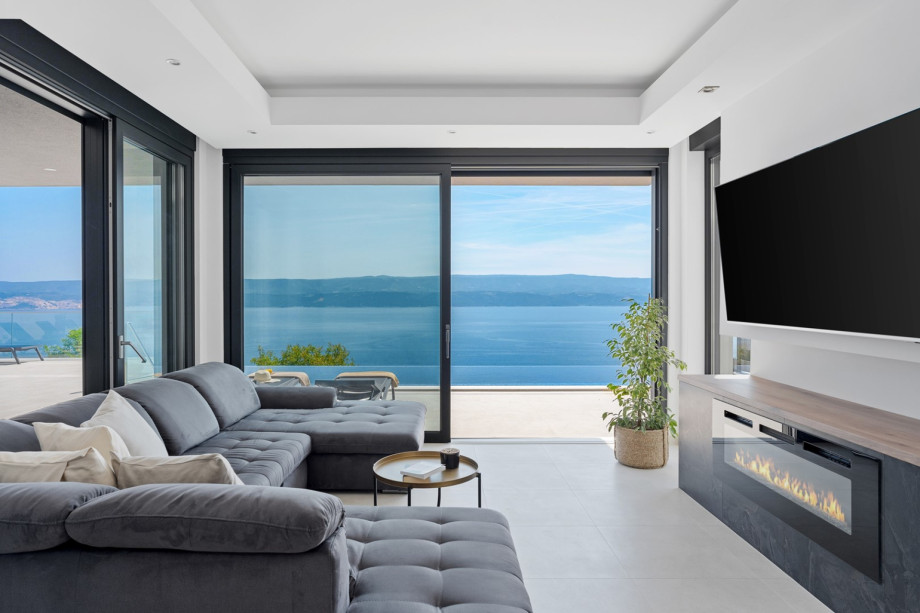 Modern furnished living area with exit to the pool.