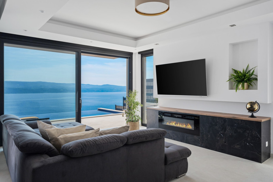 A living room with a flat-screen TV, free WiFi, a Hi-Fi speaker, IPTV channels, an artificial fireplace