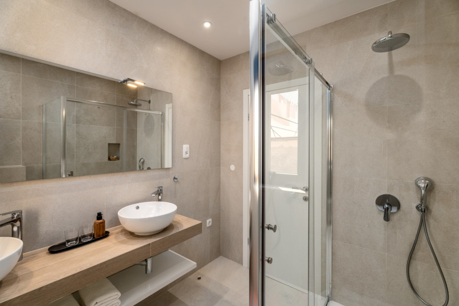 En-suite bathroom with a shower, double sink, and toilet.
