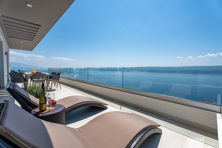 A terrace with 2 deck chairs and a dining table, positioned at the highest floor makes this area the best choice for unforgettable sunsets with a glass of wine.