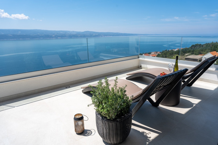 A terrace on second floor with 2 deck chairs