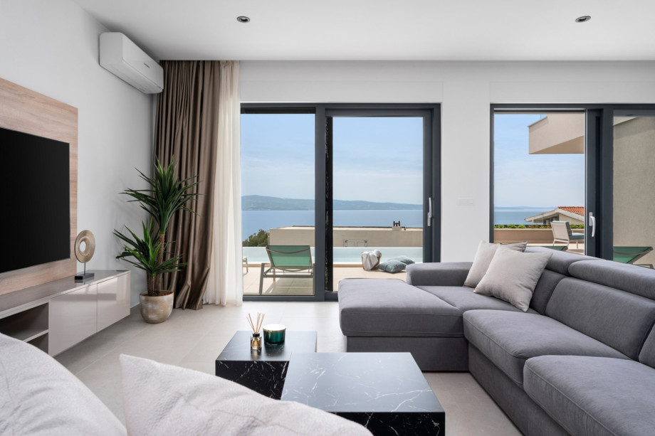 Nicely decorated living room with floor-to-ceiling glass doors toward the pool
