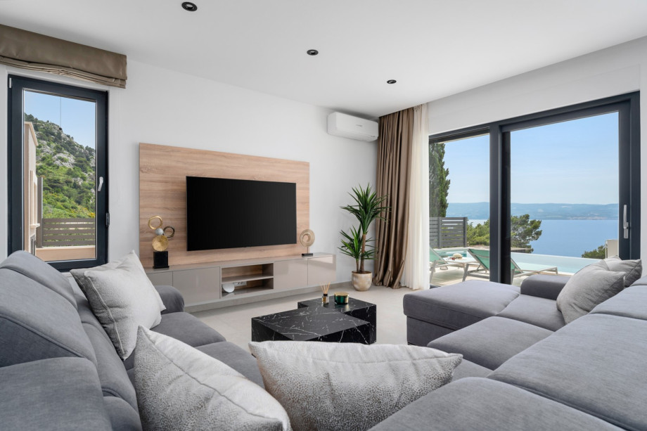 Modern furnished living area with exit to the pool.