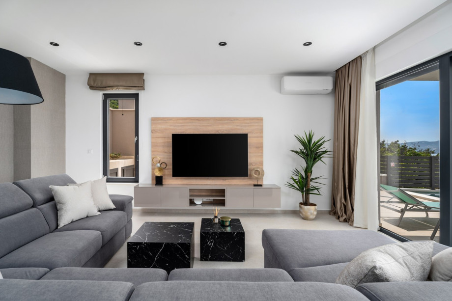 Villa Una offers floor-to-ceiling glazing doors toward the pool area.