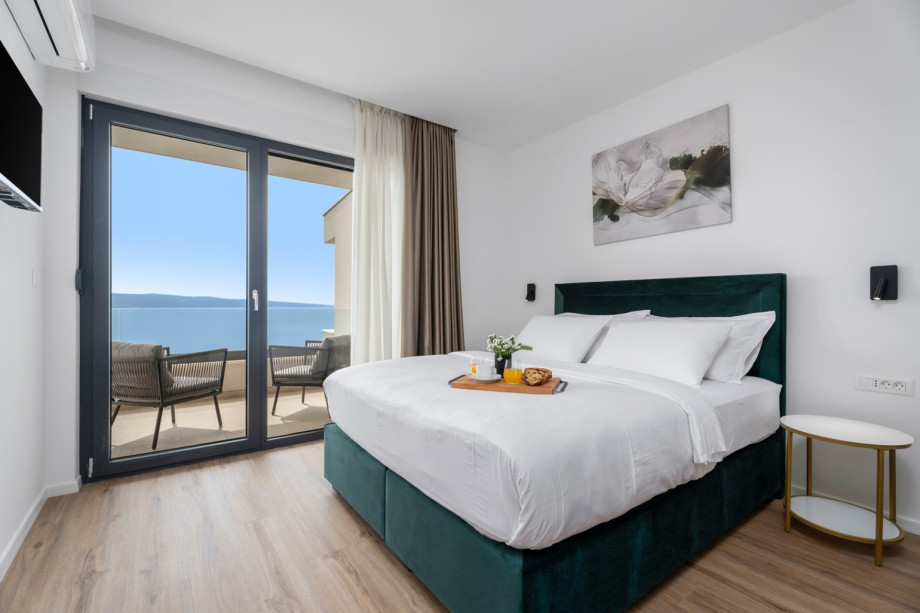 Bedroom NO2  with an A/C, a TV, and a 16sqm balcony shared with bedroom NO3 with a table and 2 chairs.