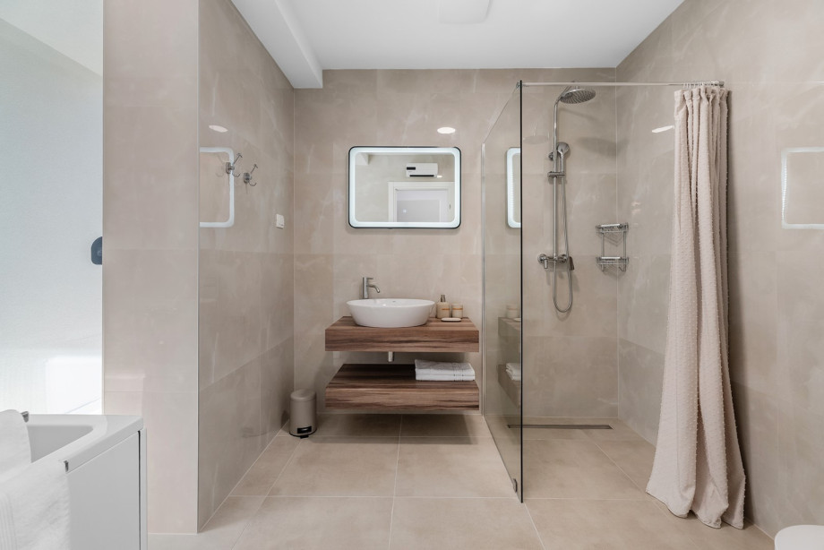 A family restroom featuring a shower and bathtub.
