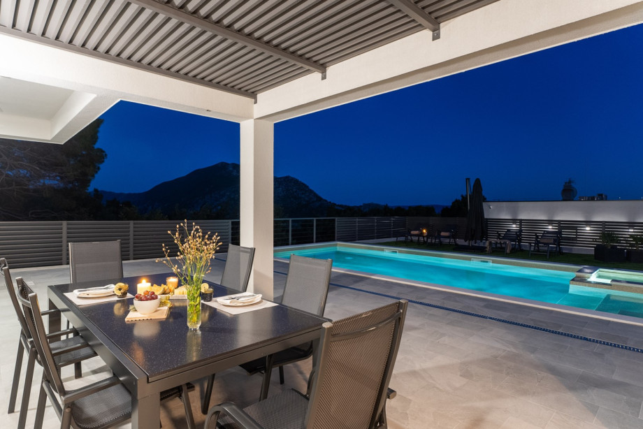 The outdoor area offers a covered dining area and a traditional barbecue