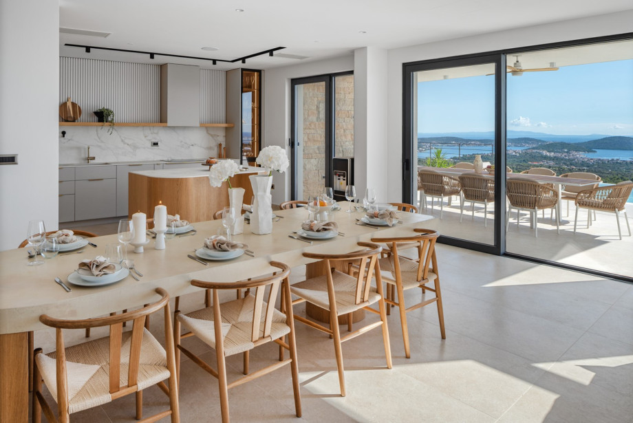 A fully equipped kitchen with a kitchen island, a spacious and stylish dining and living area